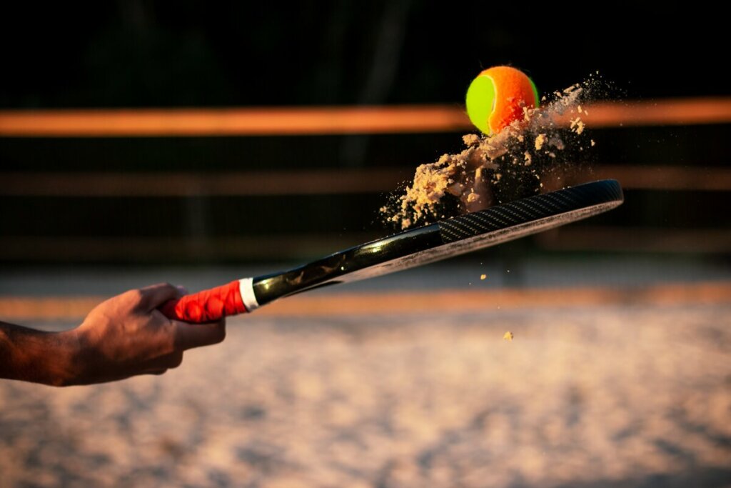 Mão masculina segurando uma raquete de beach tennis 