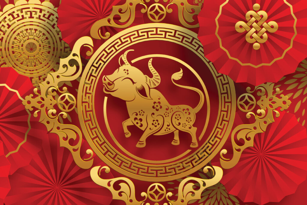 Ilustração do signo de Búfalo em um fundo vermelho com desenhos dourados