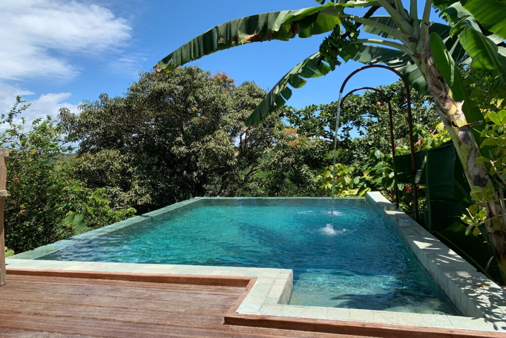 Piscina com água azul e árvores em volta