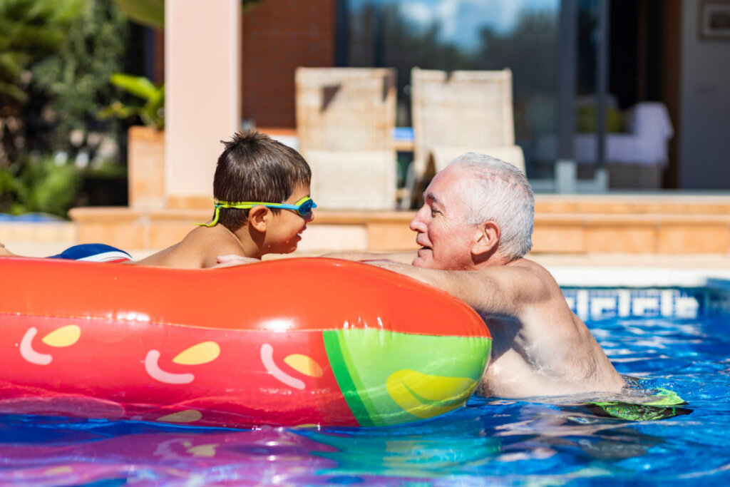 Avó e neto se divertindo em piscina