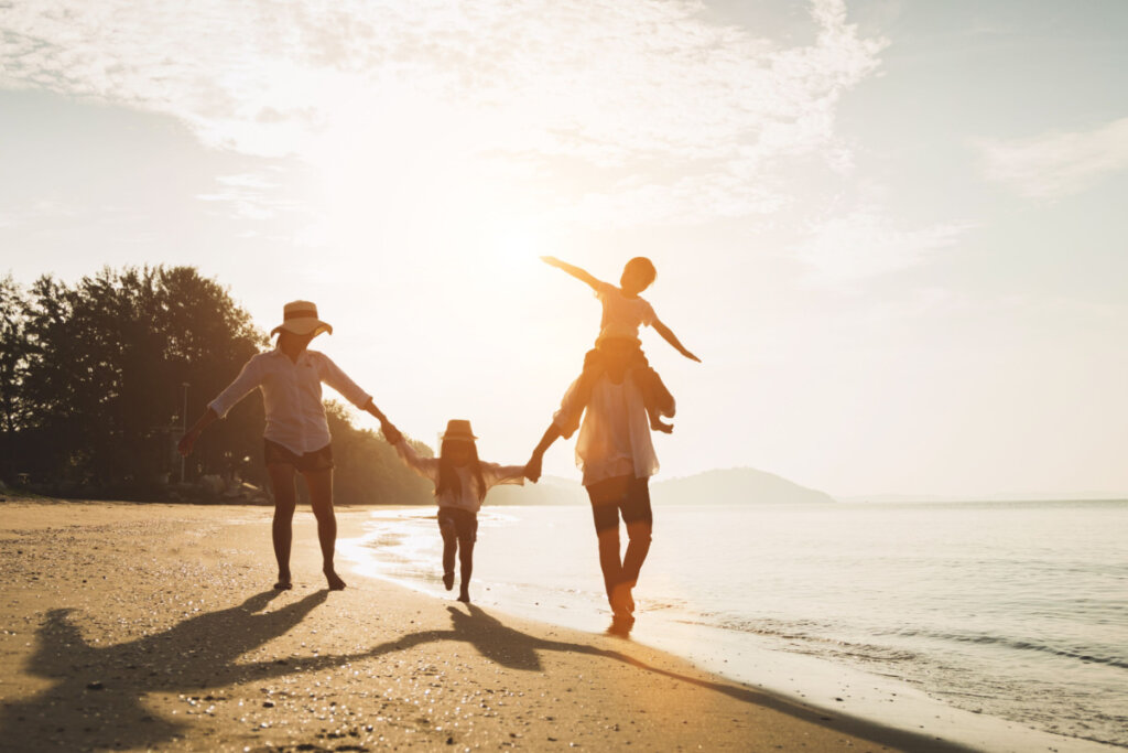 Família se divertindo em uma praia tropical ao pôr do sol