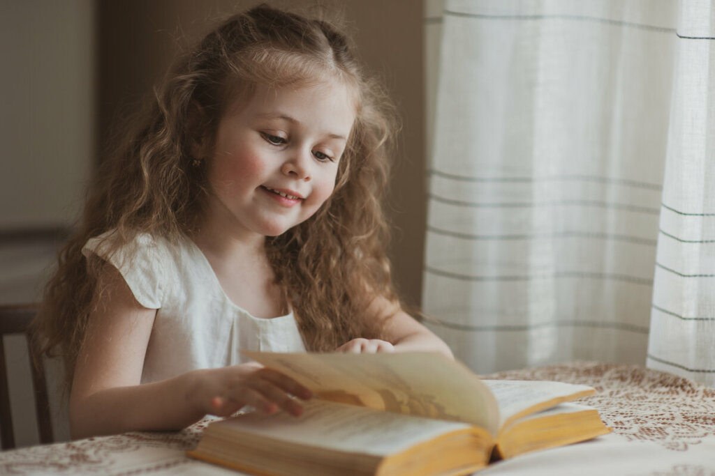 Menina sorrindo lendo um livro