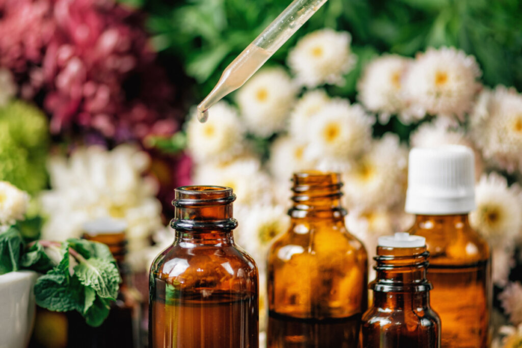 Vários frascos de óleo essencial com plantas e flores medicinais