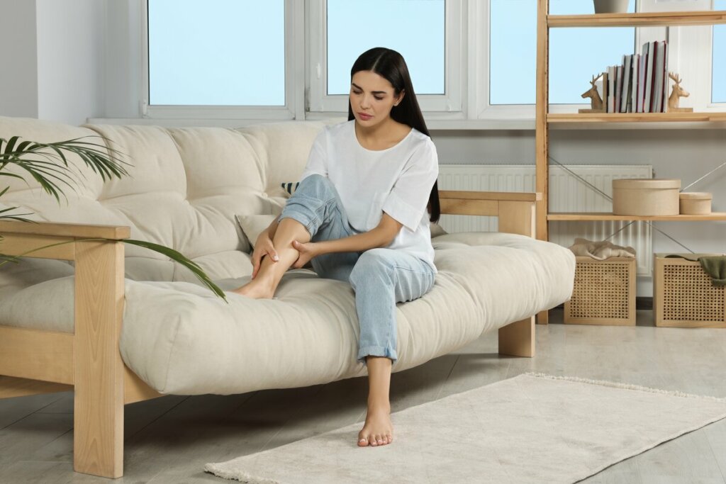 Mulher sentada em um sofá olhando para as pernas