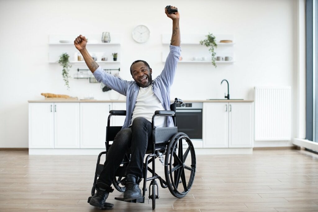 Homem sentado feliz em uma cadeira de rodas