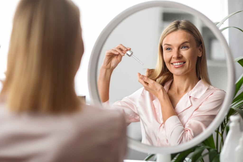 Mulher aplicando produto nos cabelos loiros