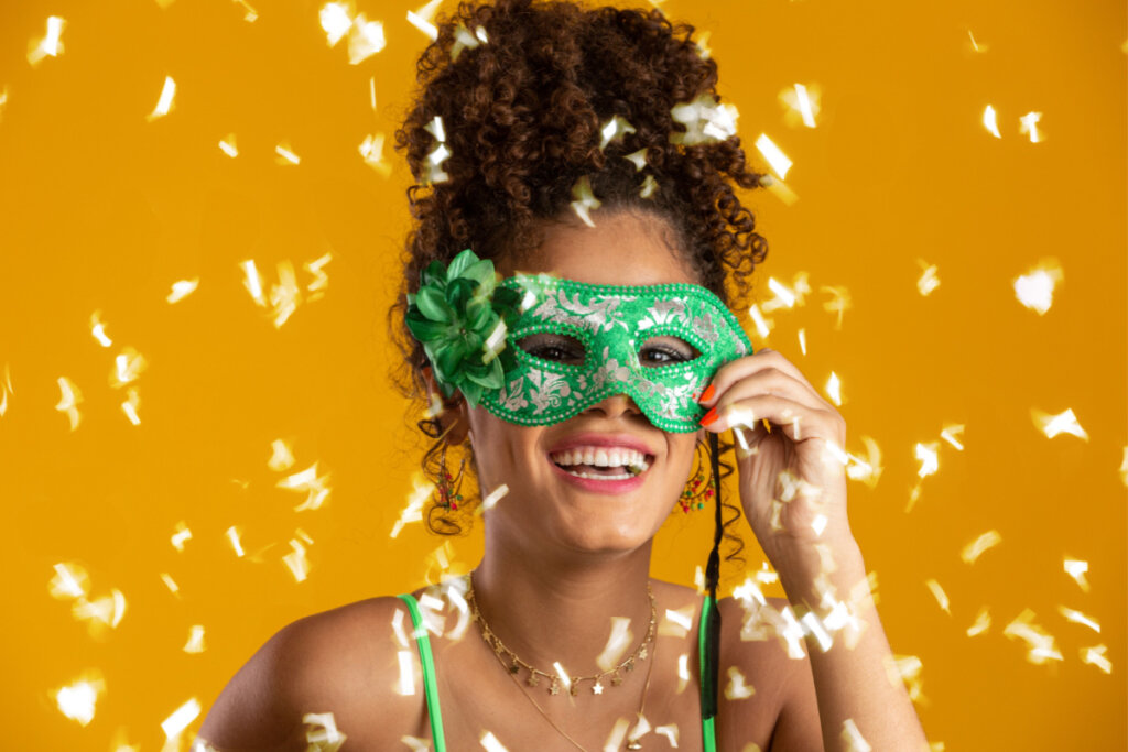 Garota com máscara de carnaval verde e cabelo em coque