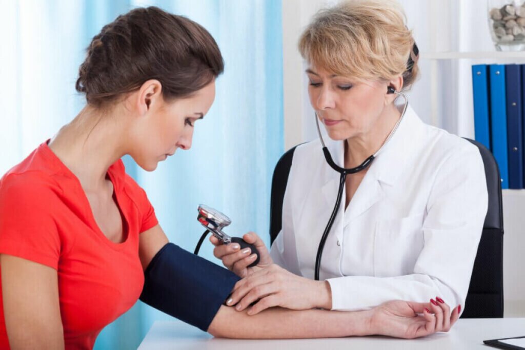 Médica medindo a pressão de uma mulher 