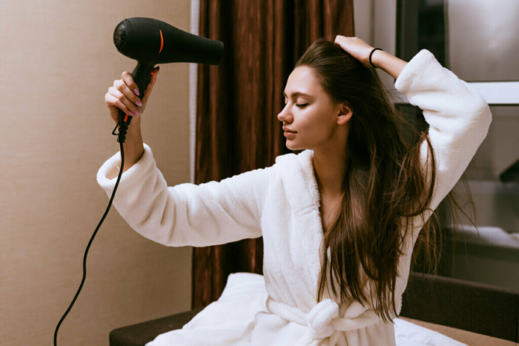 Mulher secando o cabelo com um secador 