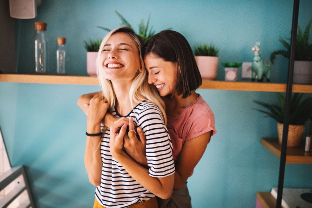 Casal de mulheres se abrançando e sorrindo