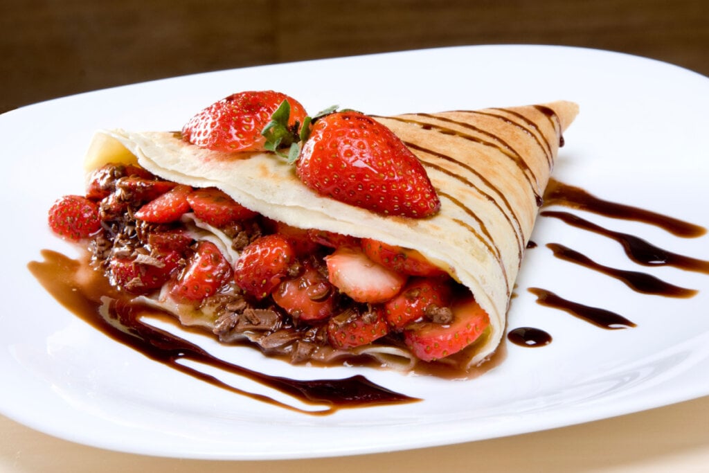 Crepe de chocolate com morango em prato branco