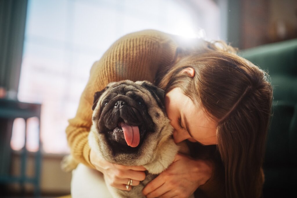 Mulher beijando um cachorro