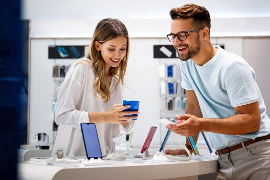 Homem e mulher olhando um celular em uma loja
