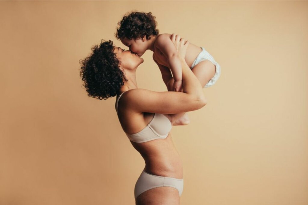 Mulher vestindo langerie brincando com um bebê