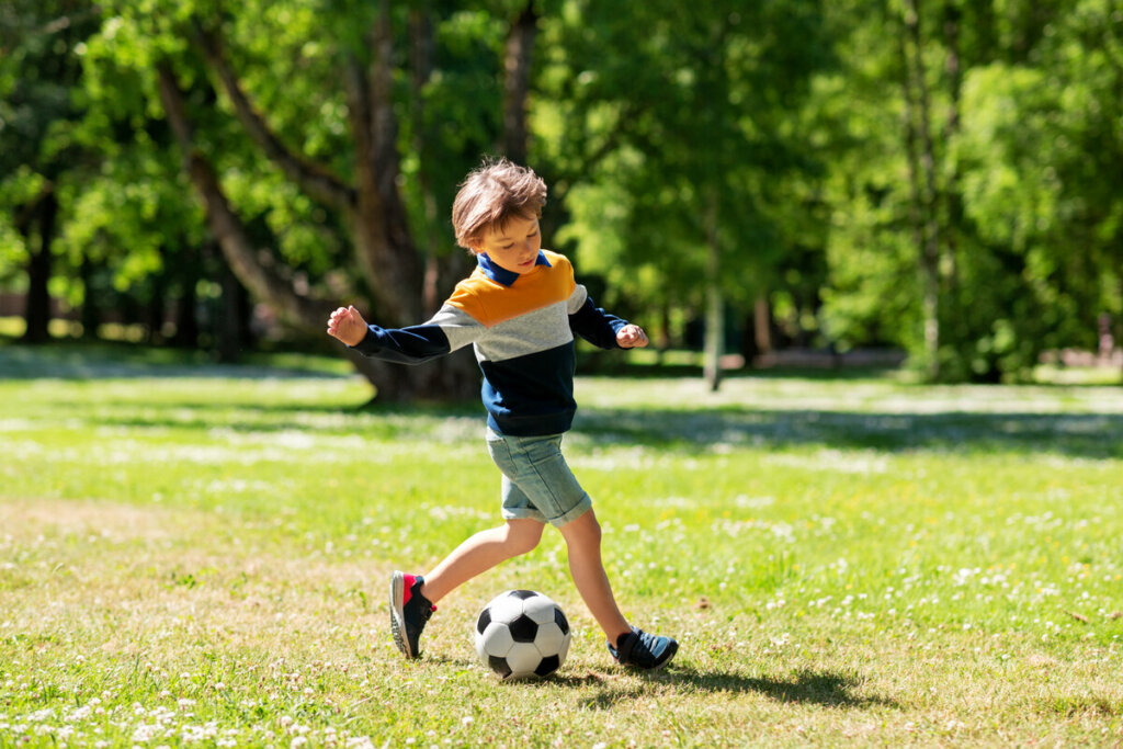 Menino jogando bola em um parque