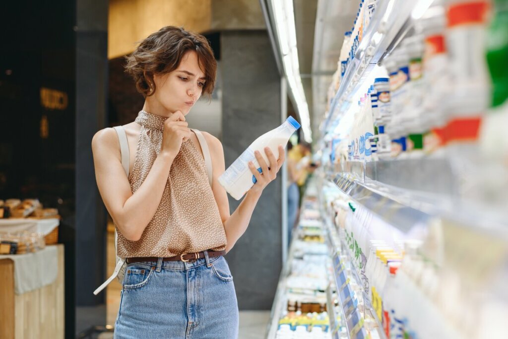 Mulher em um supermercado verificando a validade de um produto