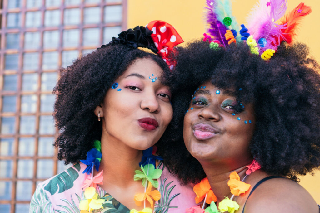 Duas mulheres com o rosto junto e maquiadas para o Carnaval 