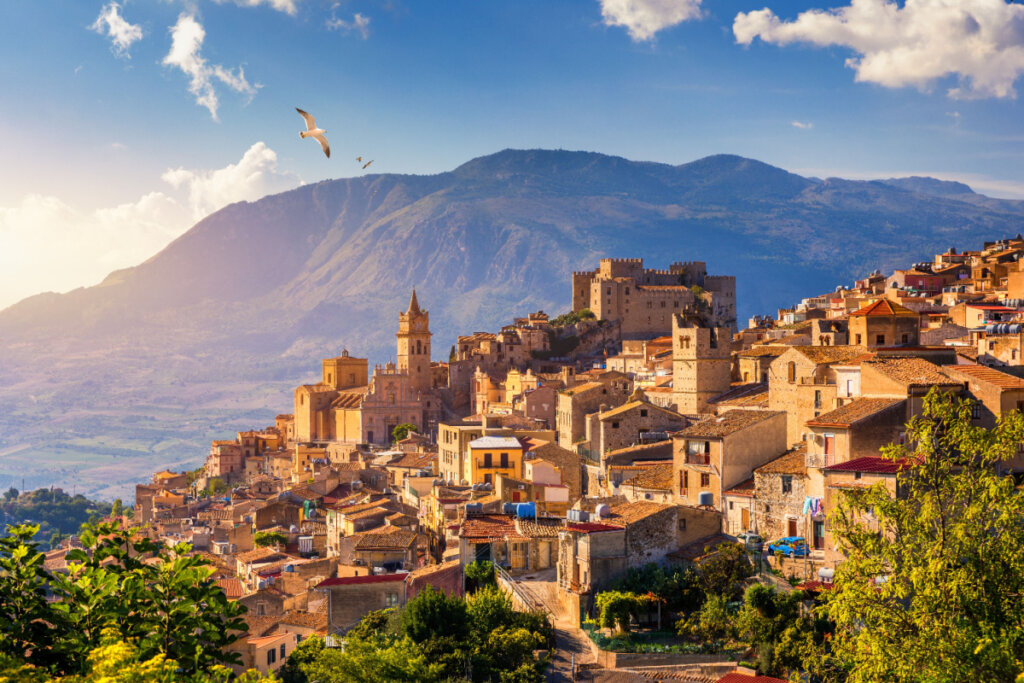 Foto de vilarejos em Sicília e, atrás, formações montanhosas