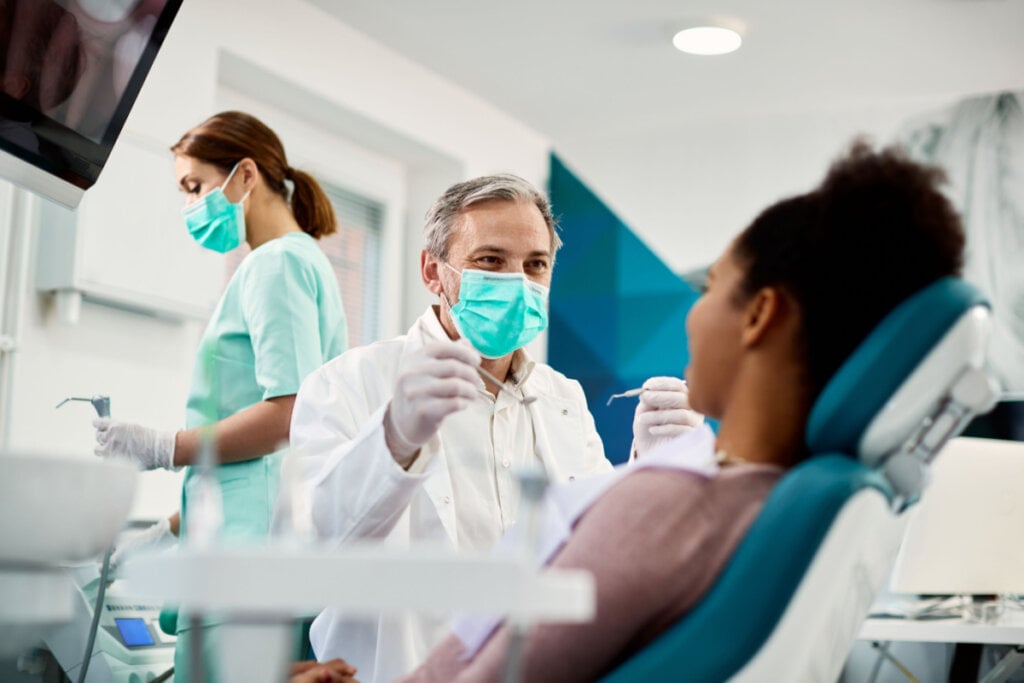 Dentista e paciente em consultório