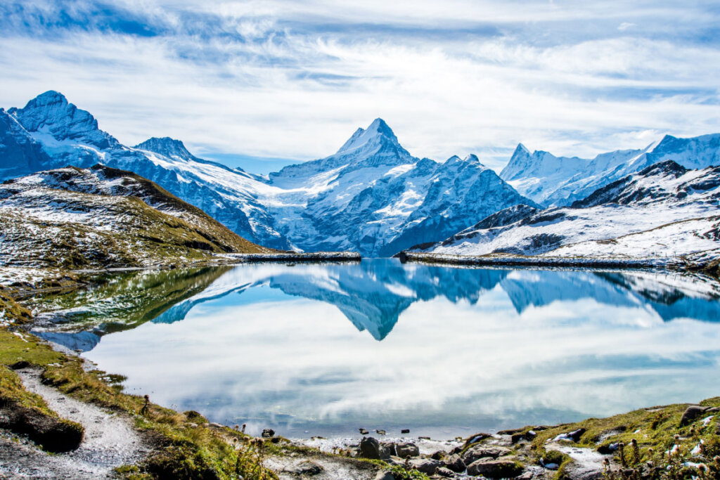 montanhas refletindo em um lago de água cristalina
