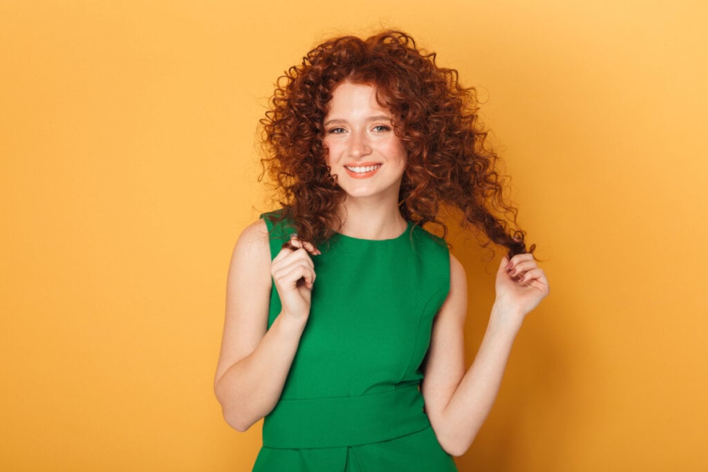 Mulher com o cabelo ruivo e cacheado