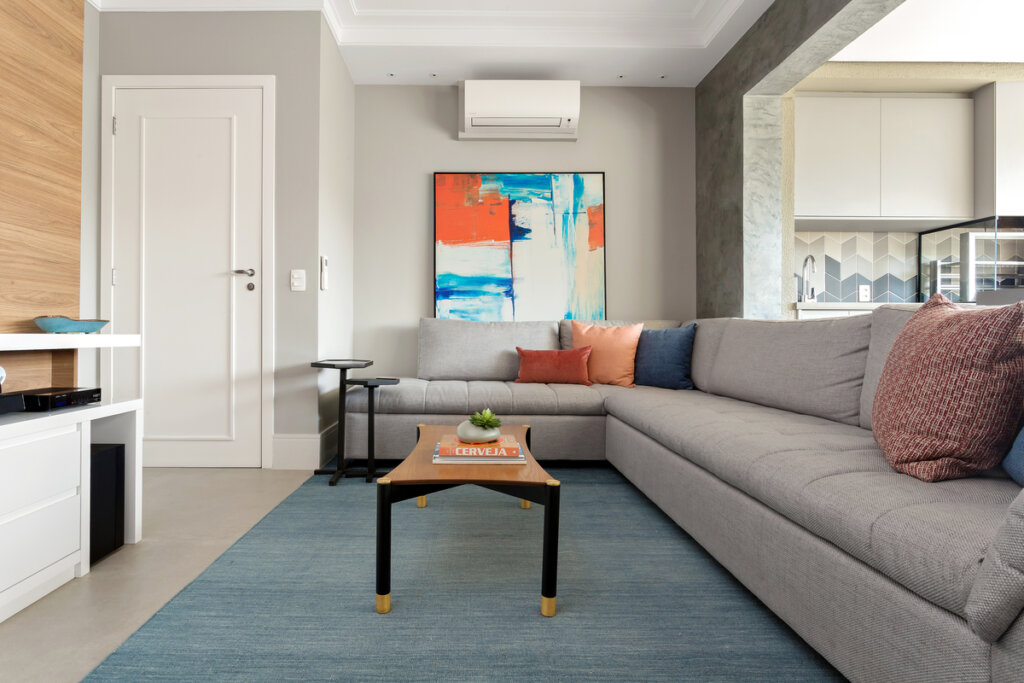 sala com sofá em L em cores neutras