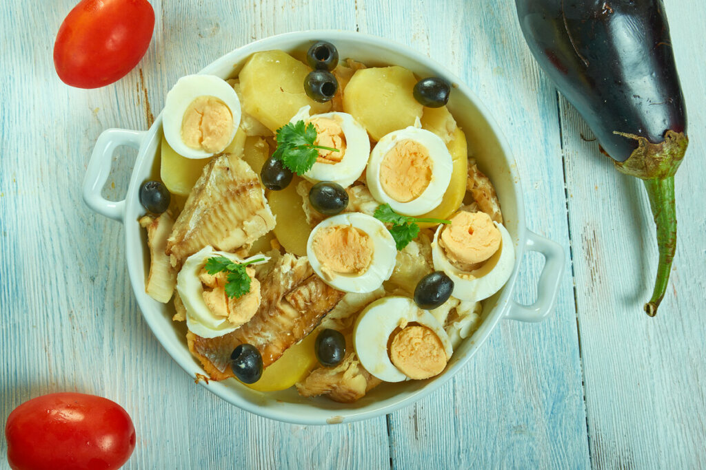 Panela branca com bacalhoada com batatas, ovos e azeitonas 