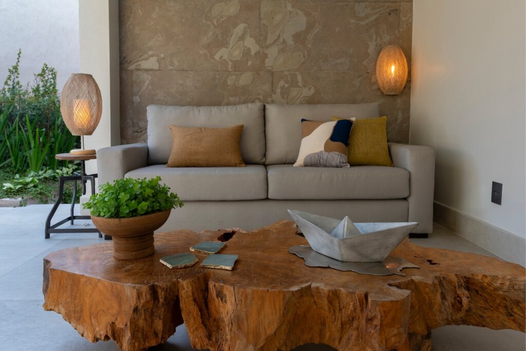 Sofá cinza com almofadas em uma sala de estar com mesa de centro de madeira