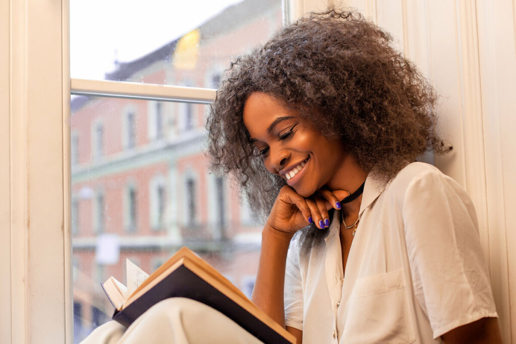 Mulher sorrindo lendo um livro