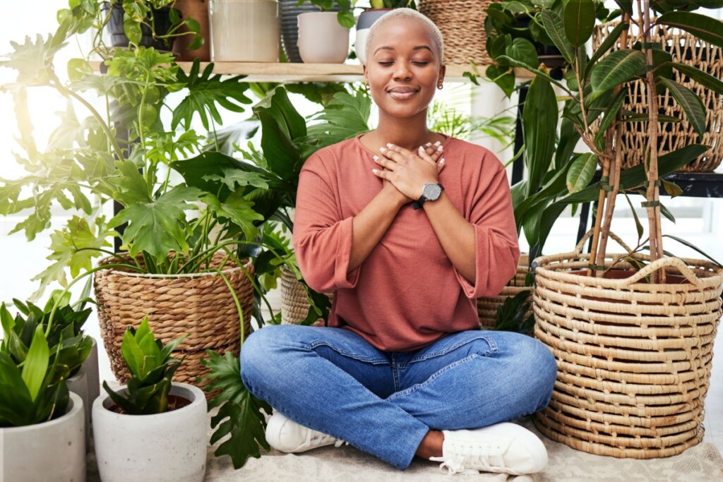 Mulher meditando no meio de plantas