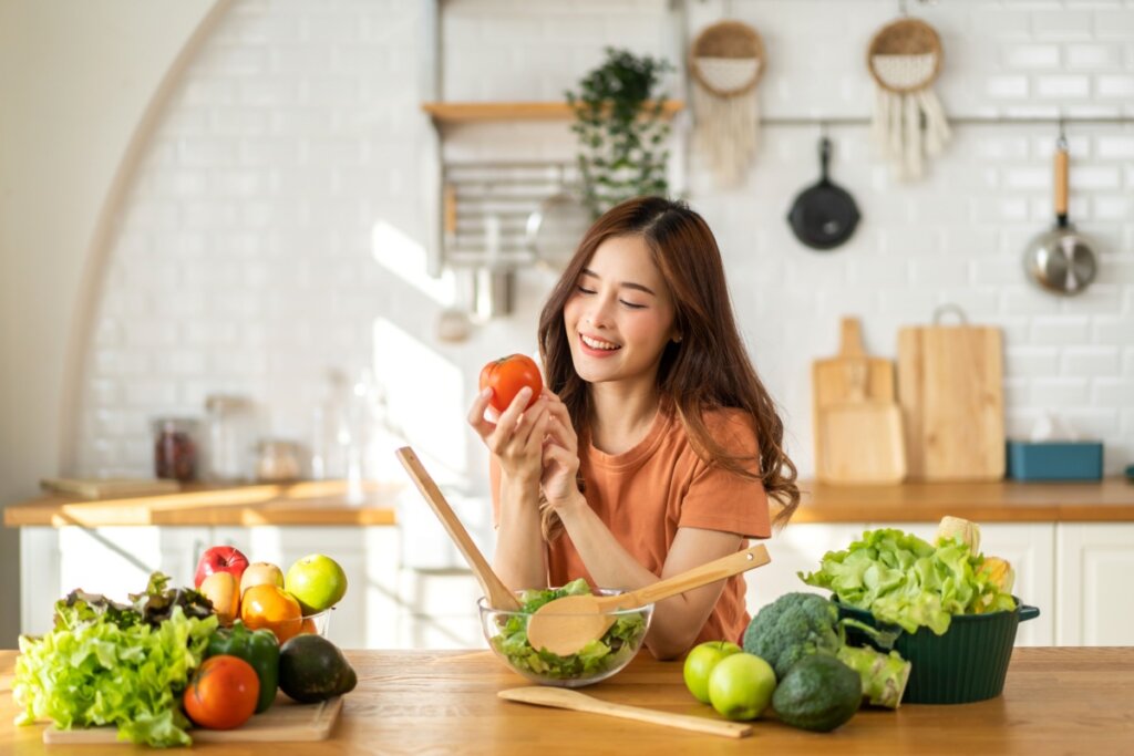 Mulher feliz preparando comida saudável em uma cozinha