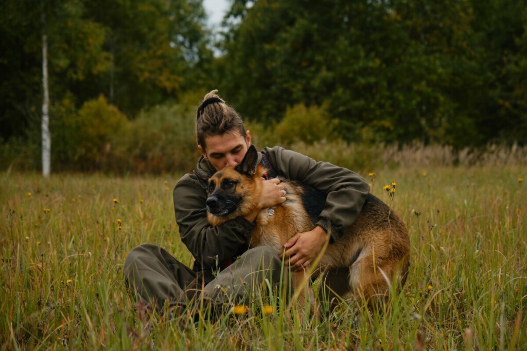 Homem abraçando um cachorro da raça pastor alemão