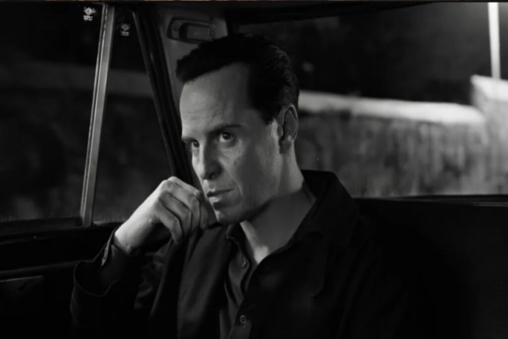 Homem sentado no banco de trás do carro em preto e branco 