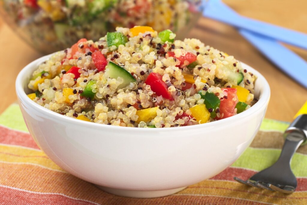 Salada de quinoa com vegetais em um bowl branco.