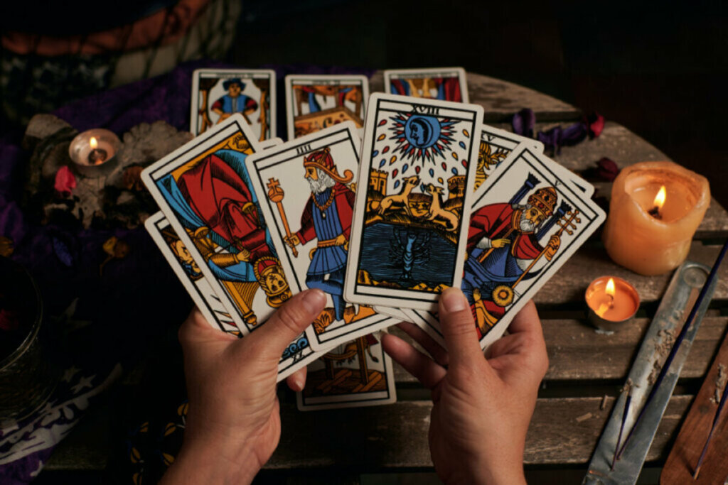 Mãos feminina segurando cartas do tarô