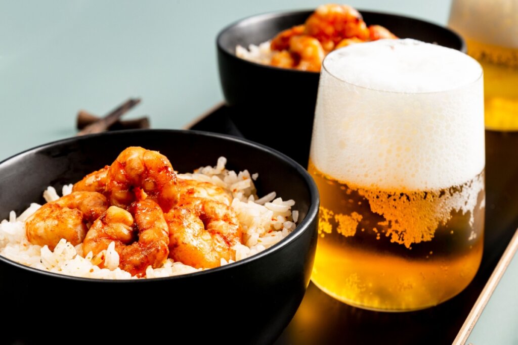 Bowl com camarão e arroz e copo com cerveja