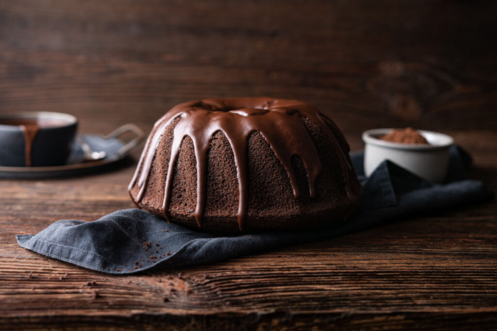 Bolo de chocolate com cobertura em cima de pano preto