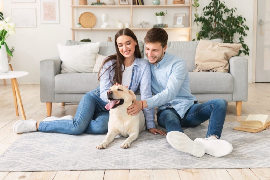 Casal sentado com cachorro no chão