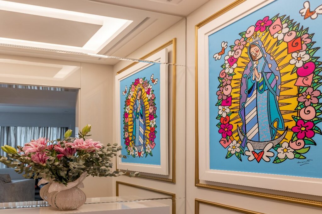 hall de entrada com uma bancada e um vaso de flores e na parede do lado direito um quadro com Nossa Senhora de Guadalupe
