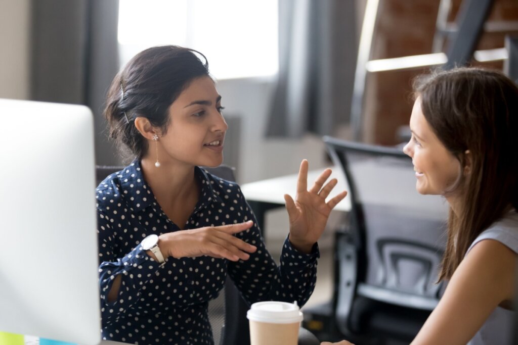 duas mulheres conversando no ambiente de trabalho