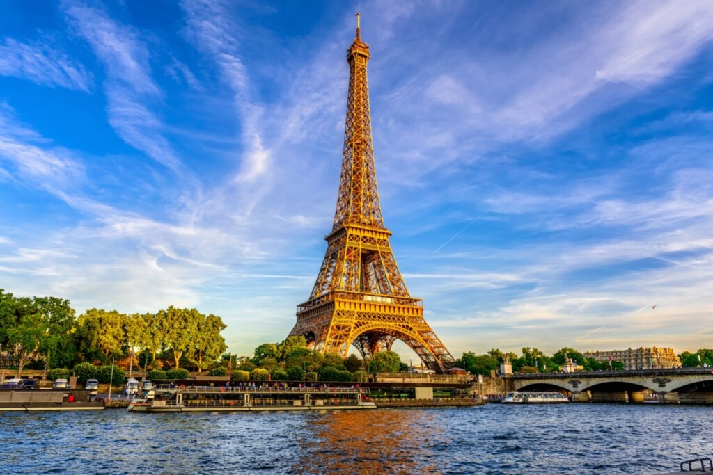Torre Eiffel no centro da foto e o fundo a cidade e o céu azul
