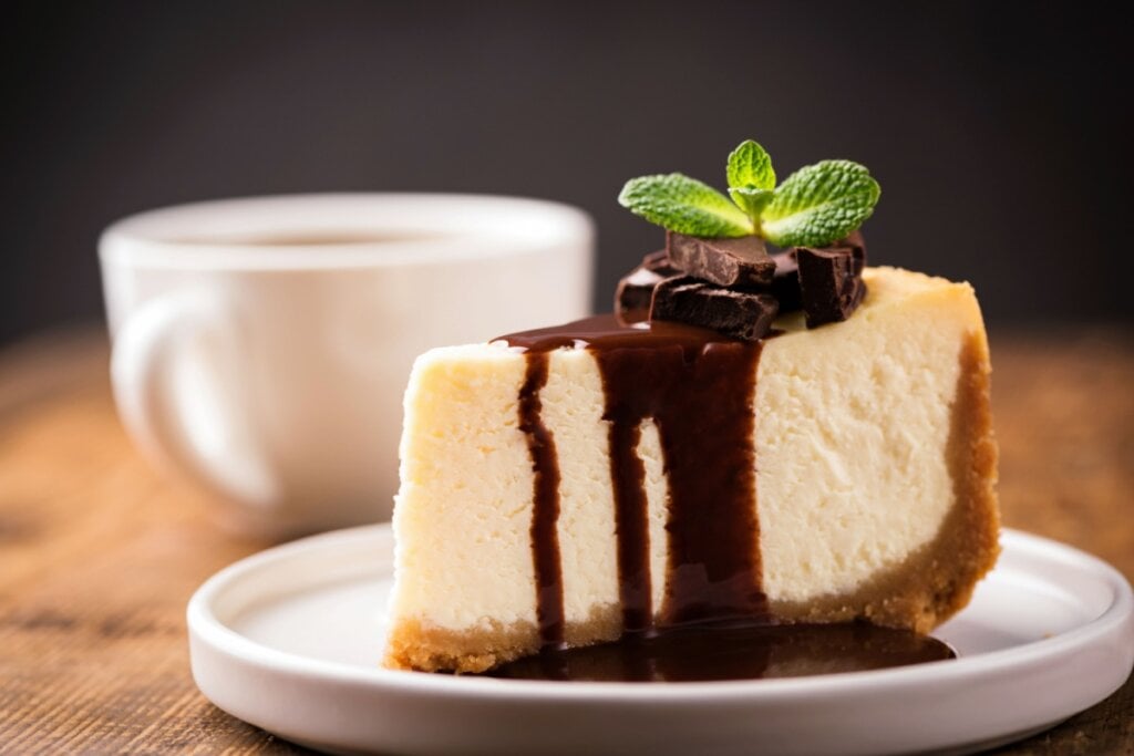 Torta branca com calda de chocolate em prato branco