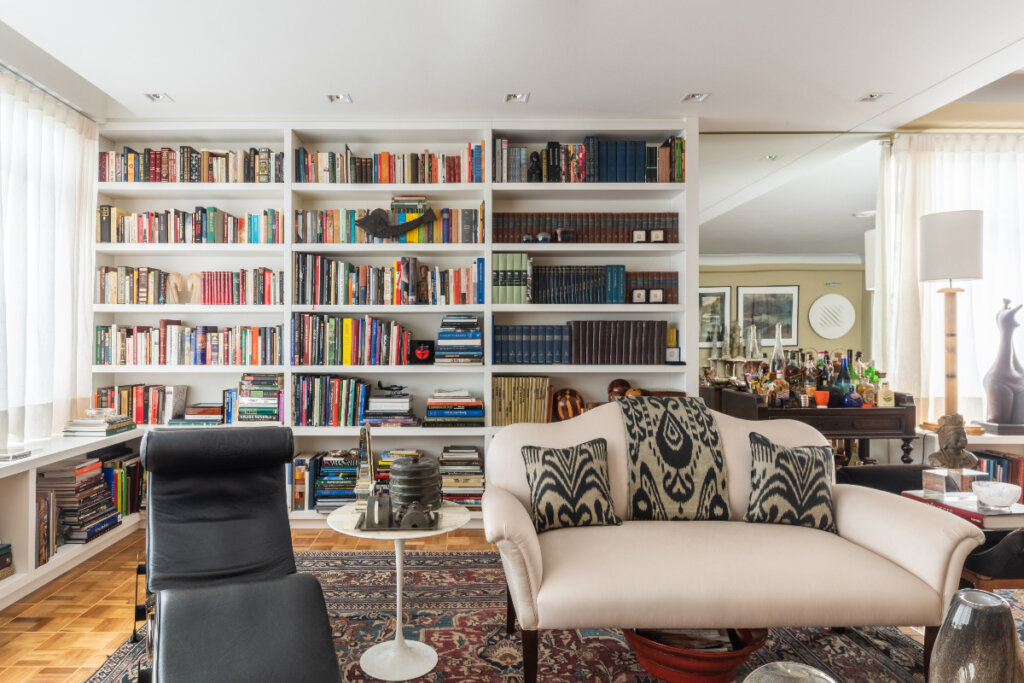 Foto de uma sala com uma prateleira grande cheia de livros