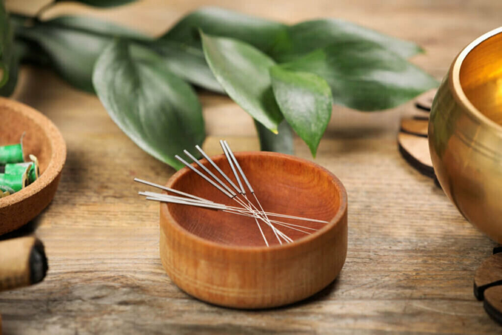 Recipiente de madeira com agulhas de acupuntura