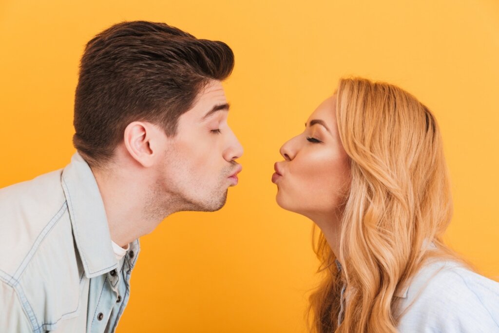 Mulher e homem fazendo bico de beijo