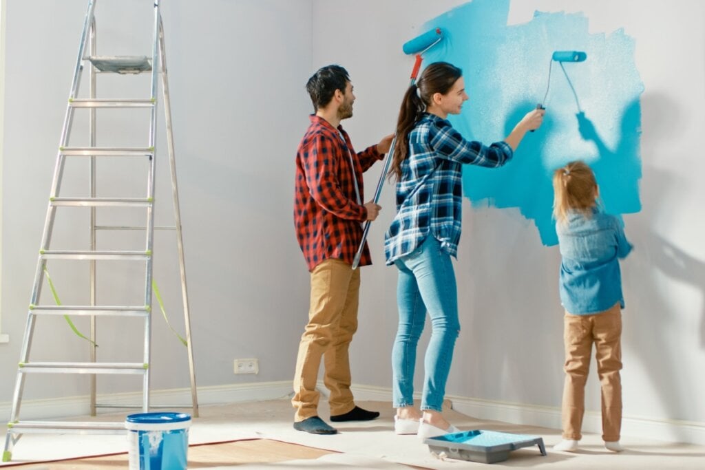 Família pintando parede de azul