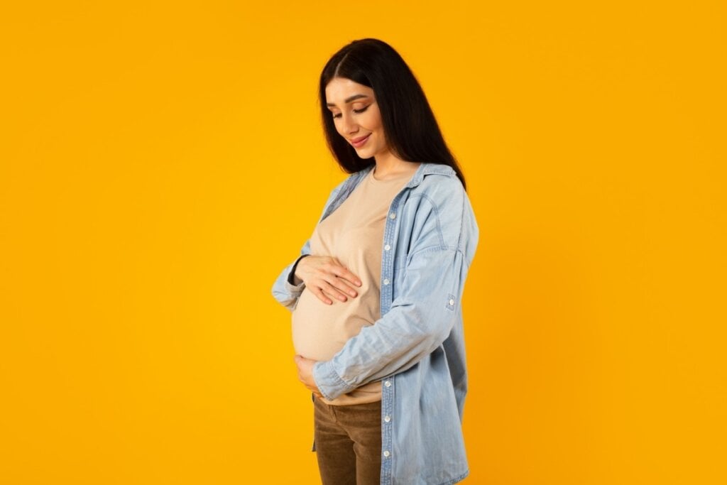 Mulher grávida olhando para barriga