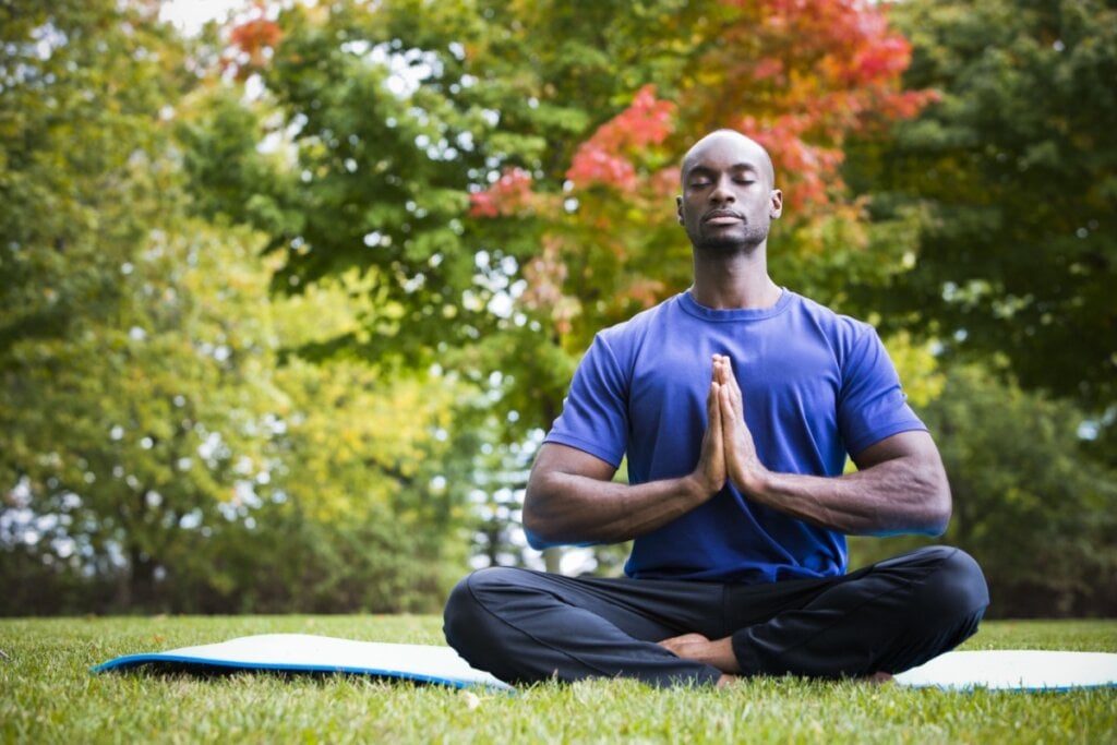 Homem praticando yoga em um parque.