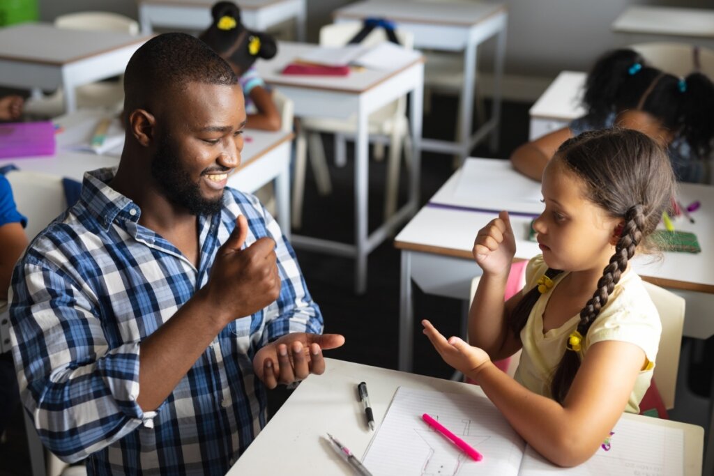 Homem e menina sentados conversando em libras