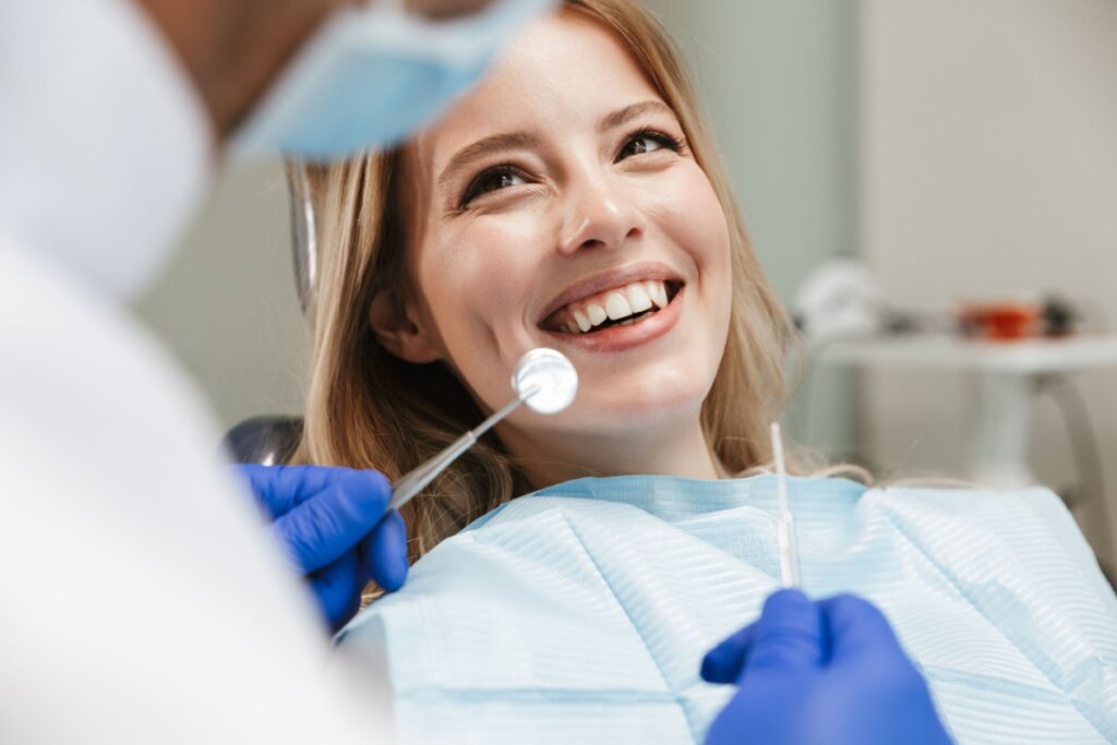 jovem sentada na cadeira odontológica no centro médico enquanto médico profissional consertando os dentes